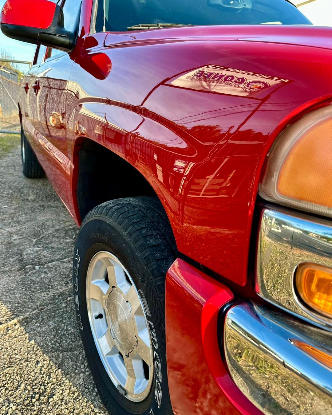 A red truck is parked on the side of the road