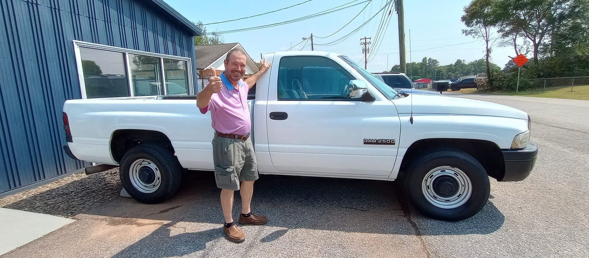 A man is standing in front of a white truck.