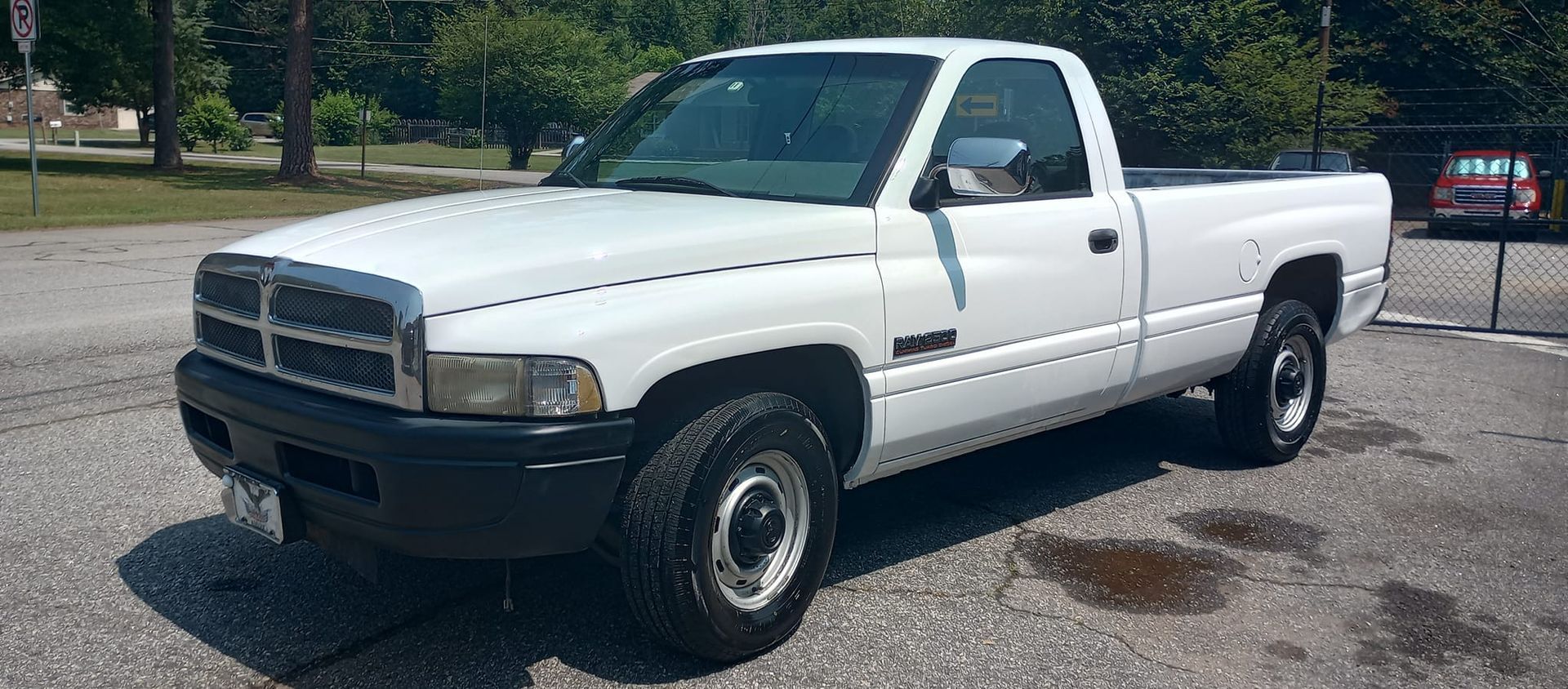A white dodge ram truck is parked in a parking lot.