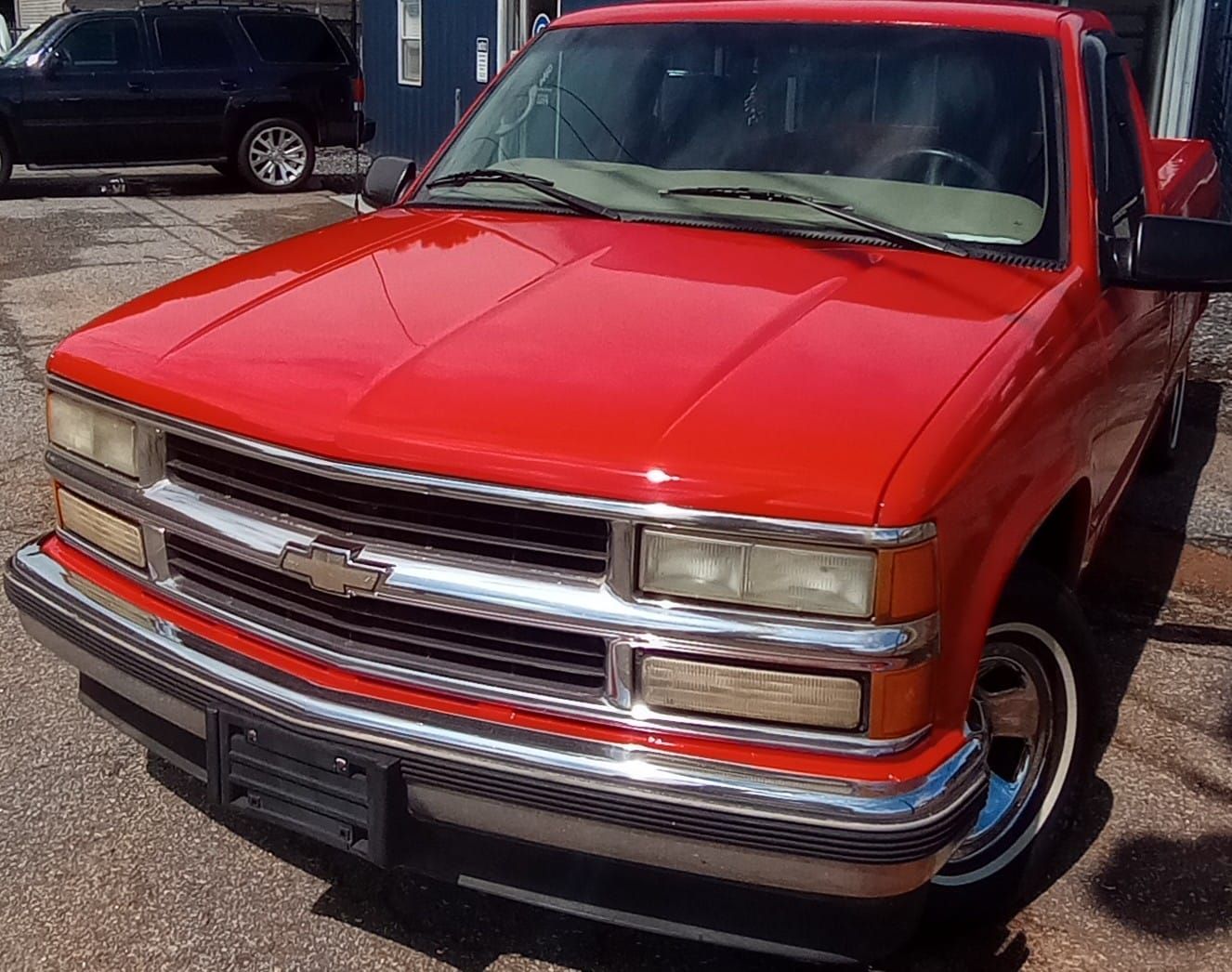 A red chevrolet truck is parked in a parking lot