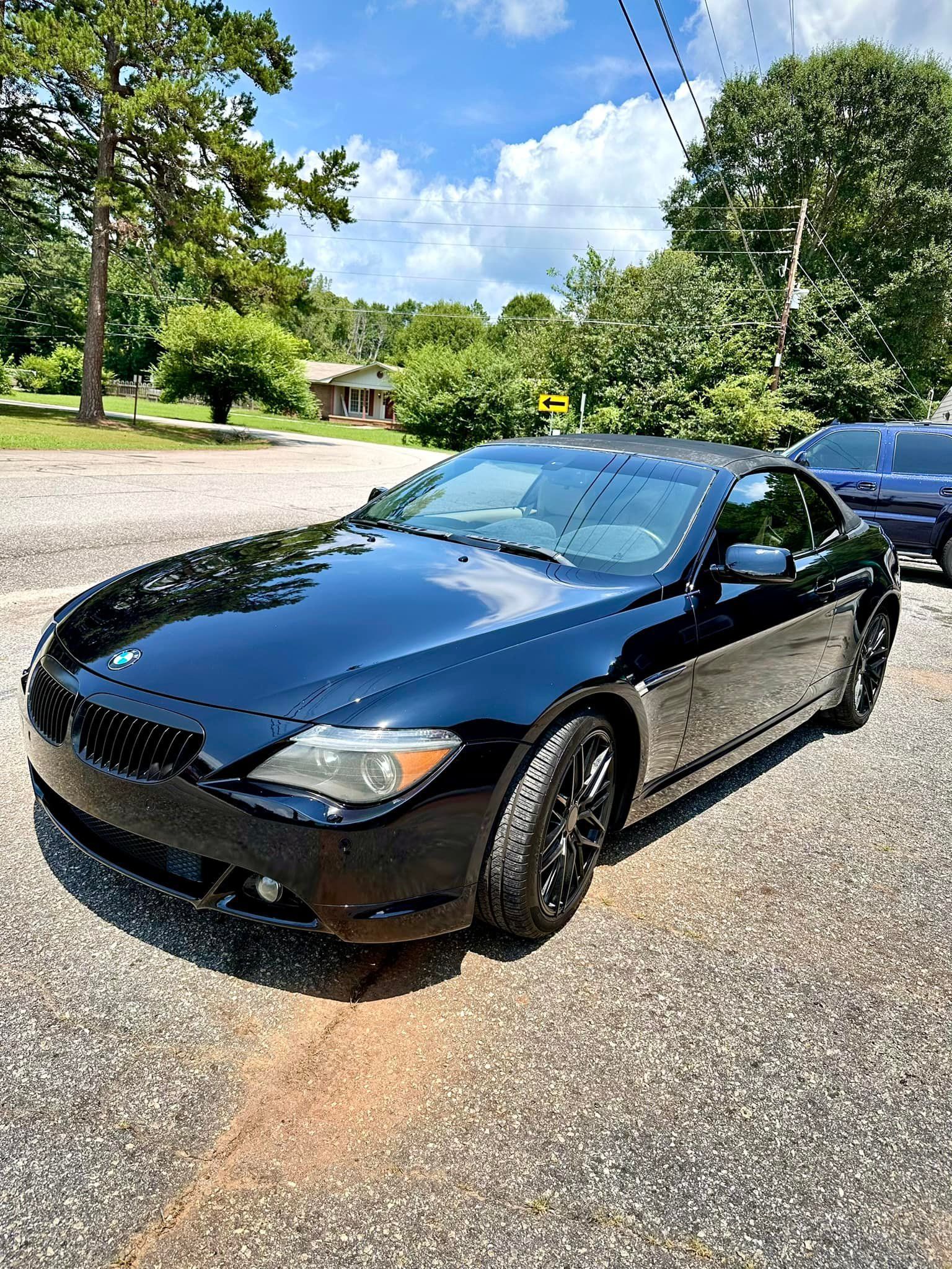 A black sports car is parked on the side of the road.