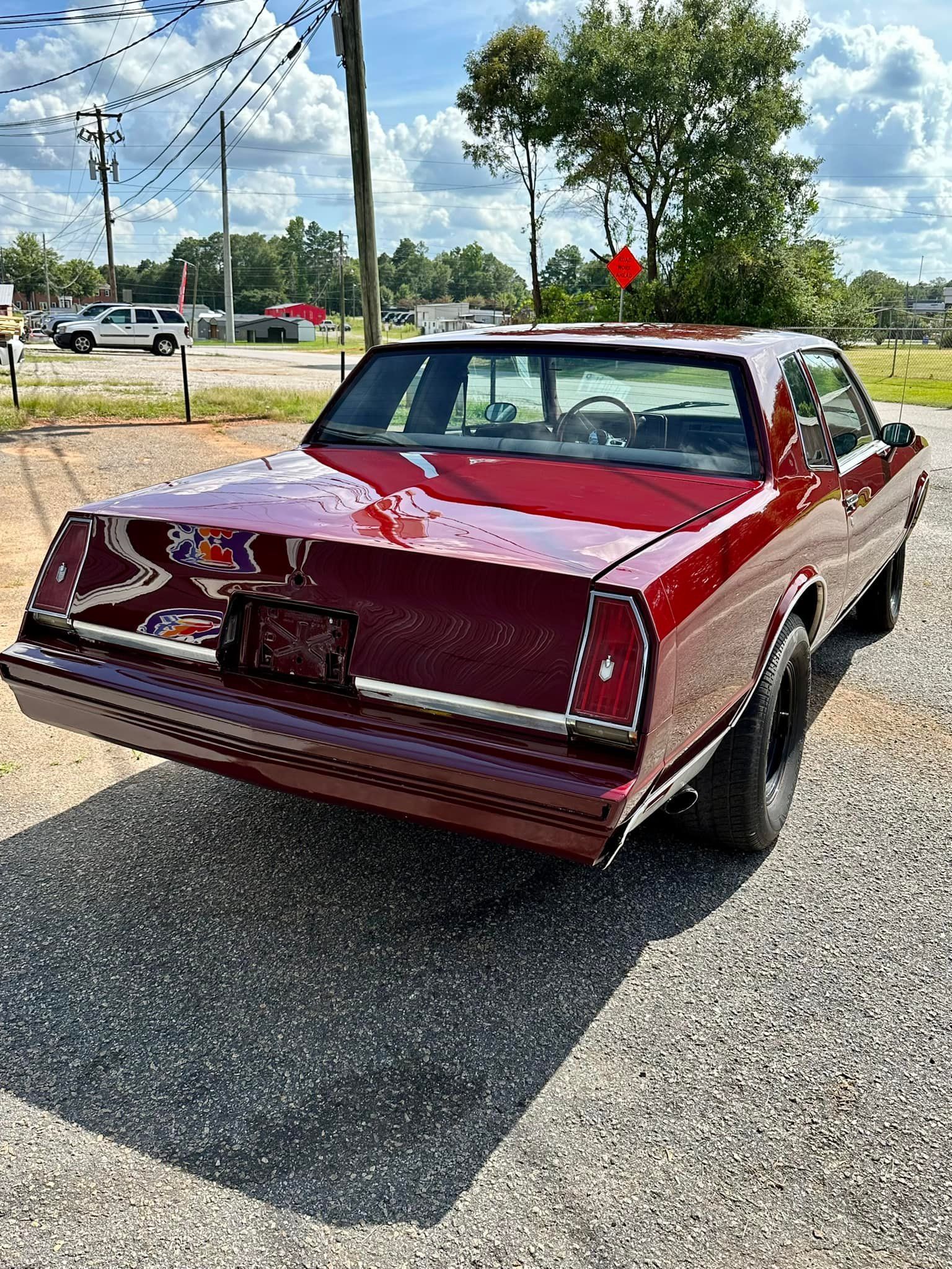 A red car is parked on the side of the road.