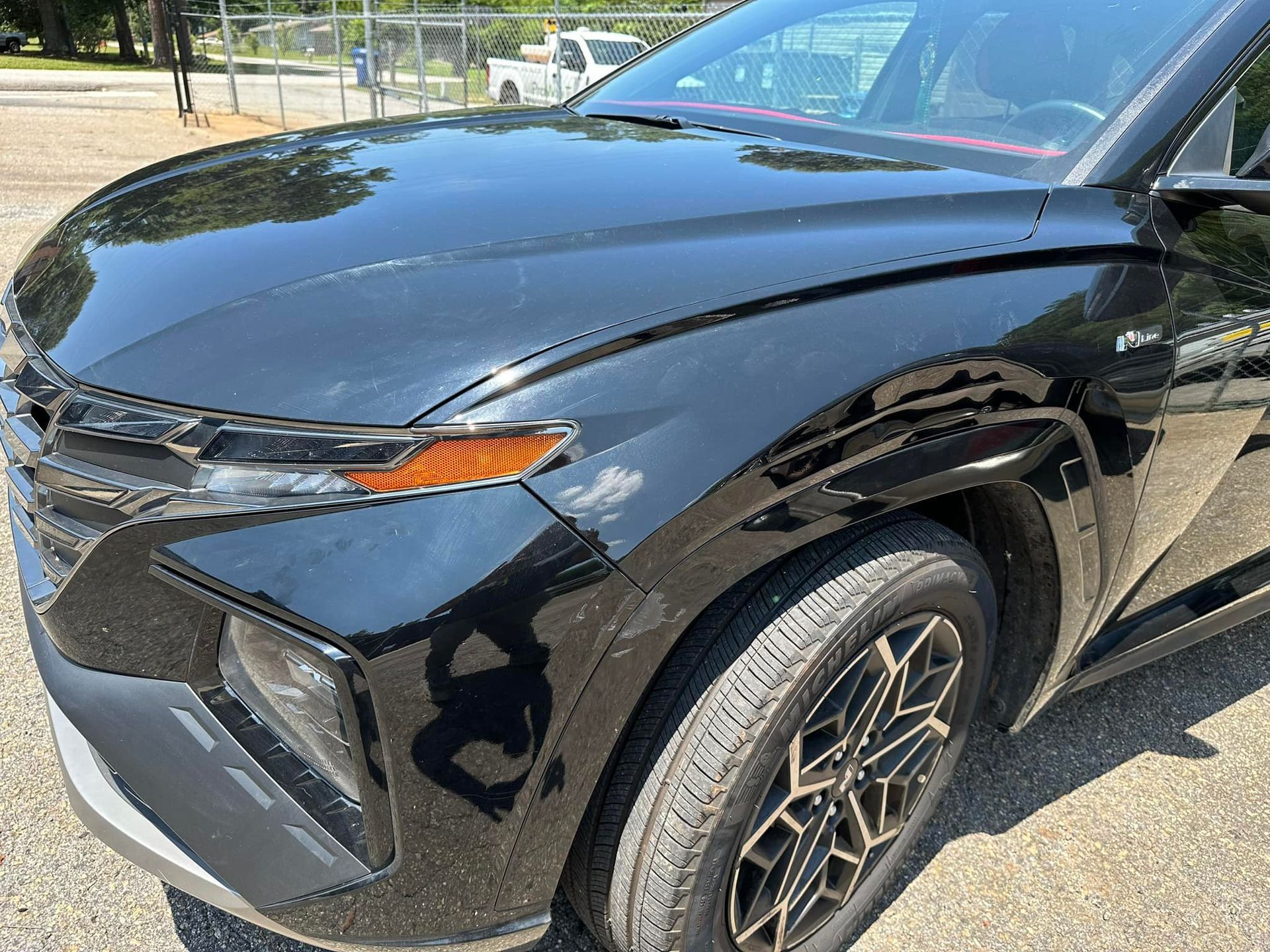 A black car is parked on the side of the road.