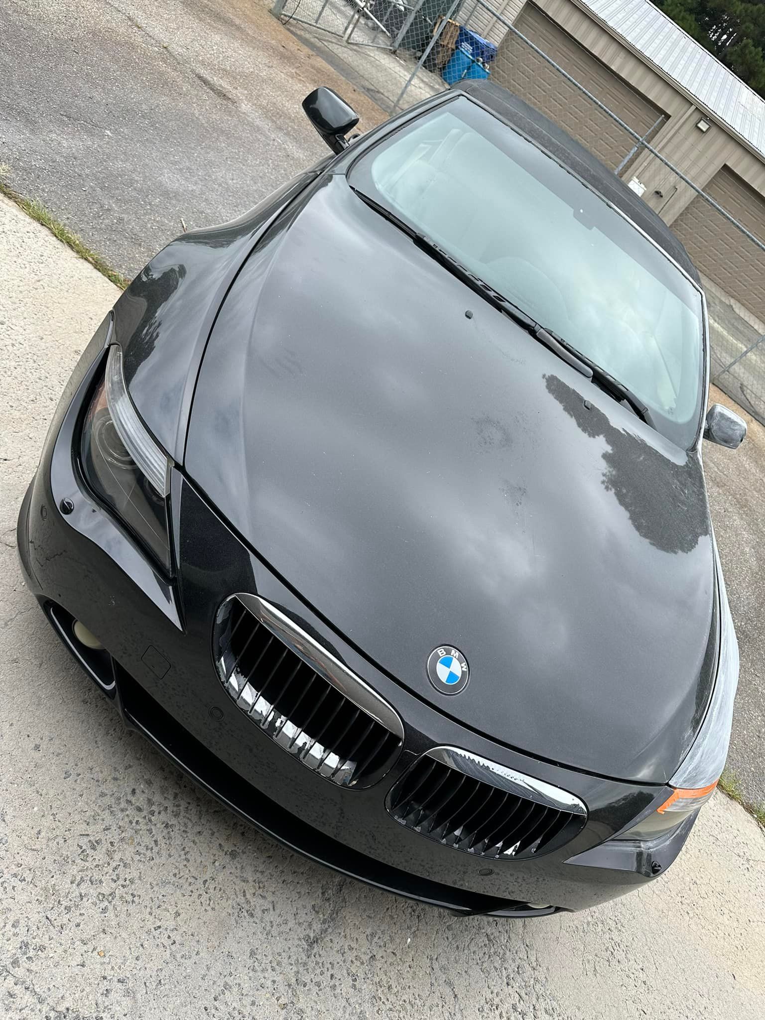 A black bmw is parked on the side of the road.