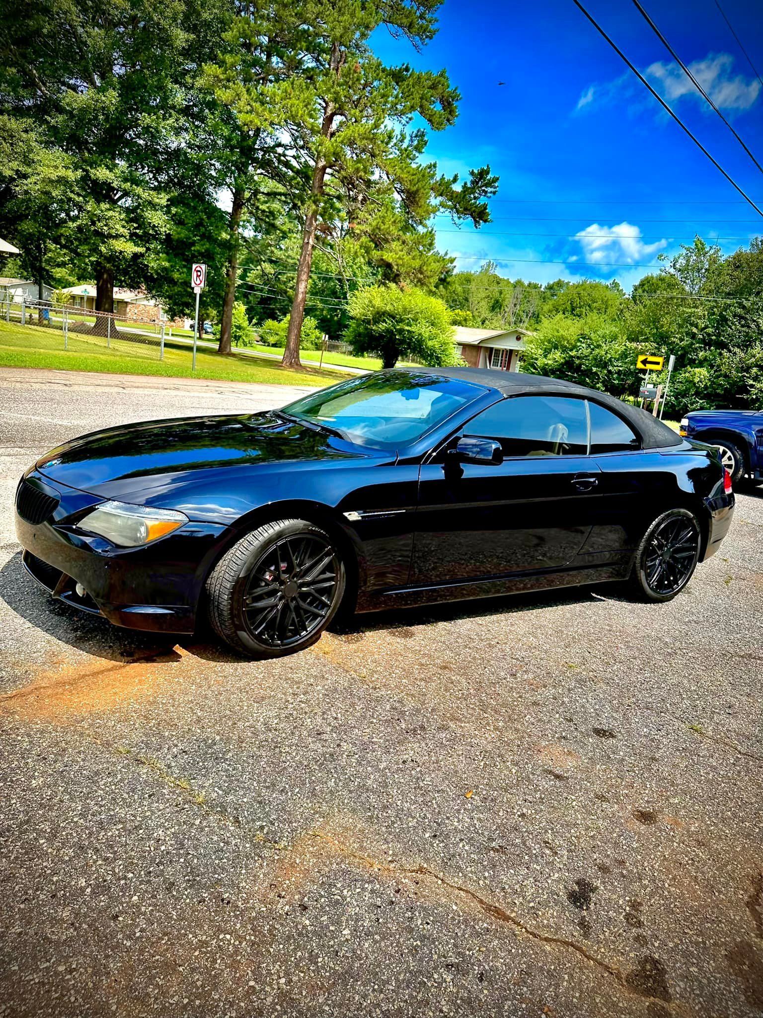 A black sports car is parked on the side of the road.