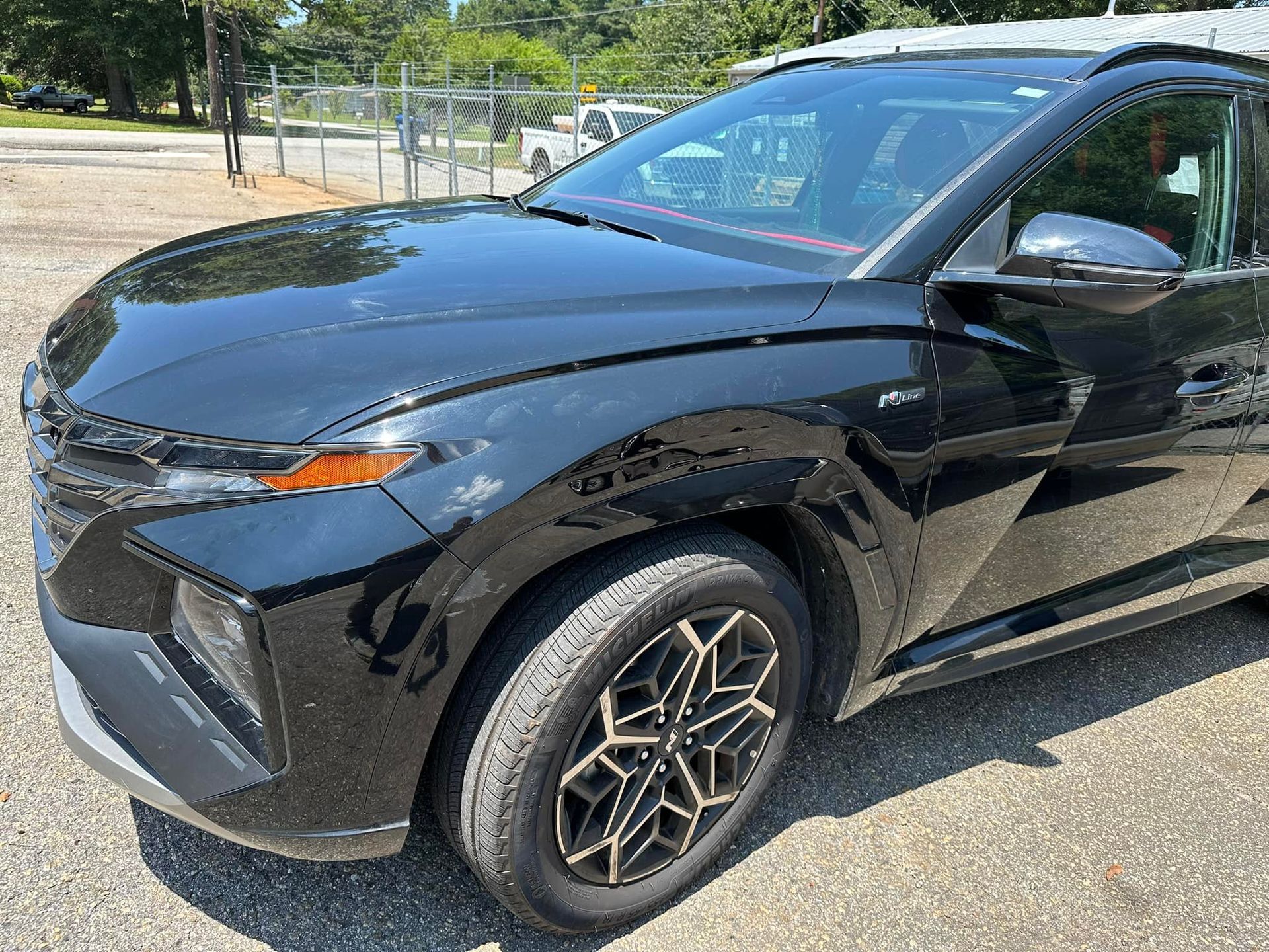 A black car is parked in a parking lot.