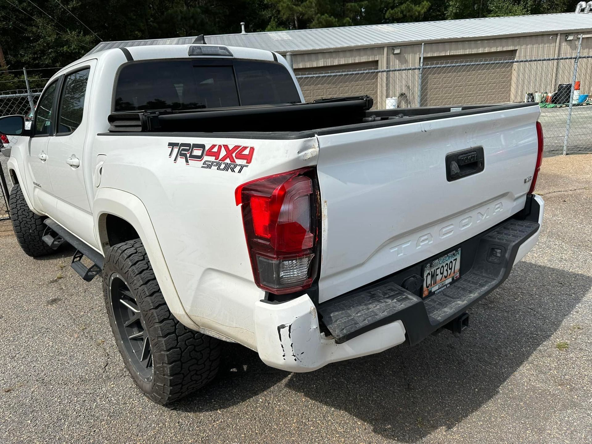 A white toyota tacoma truck is parked in a parking lot.