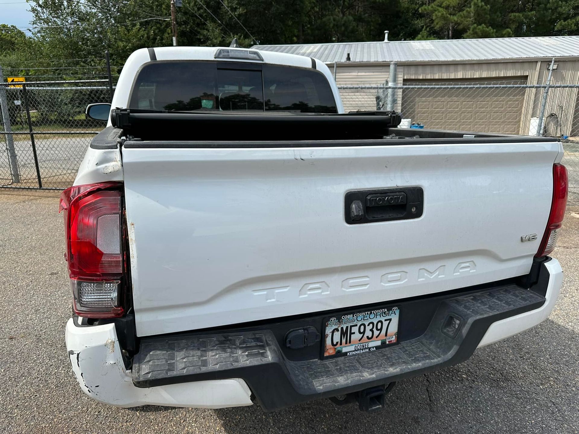 A white tacoma truck is parked in a parking lot.