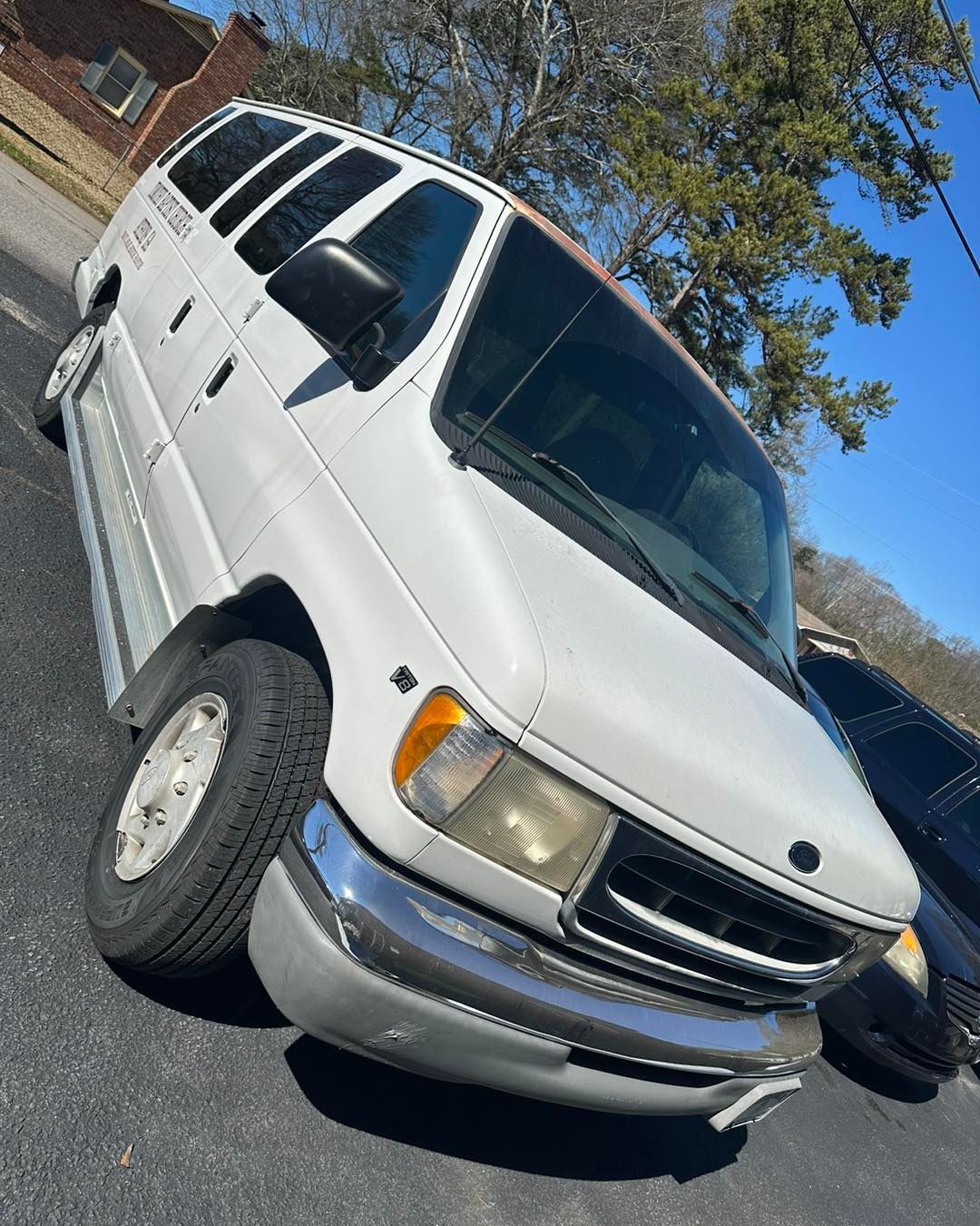 A white van is parked on the side of the road.
