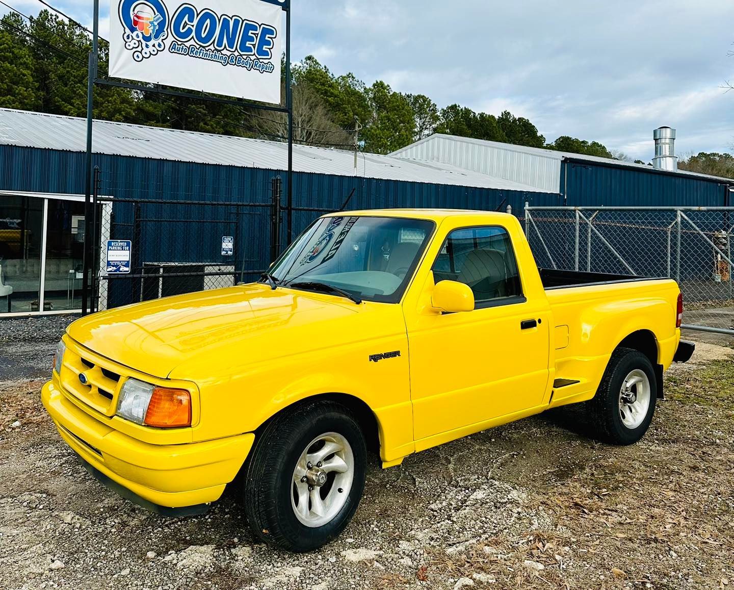 A yellow truck is parked in front of a building.