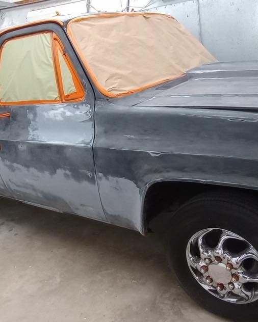 A gray car with a hood cover on it
