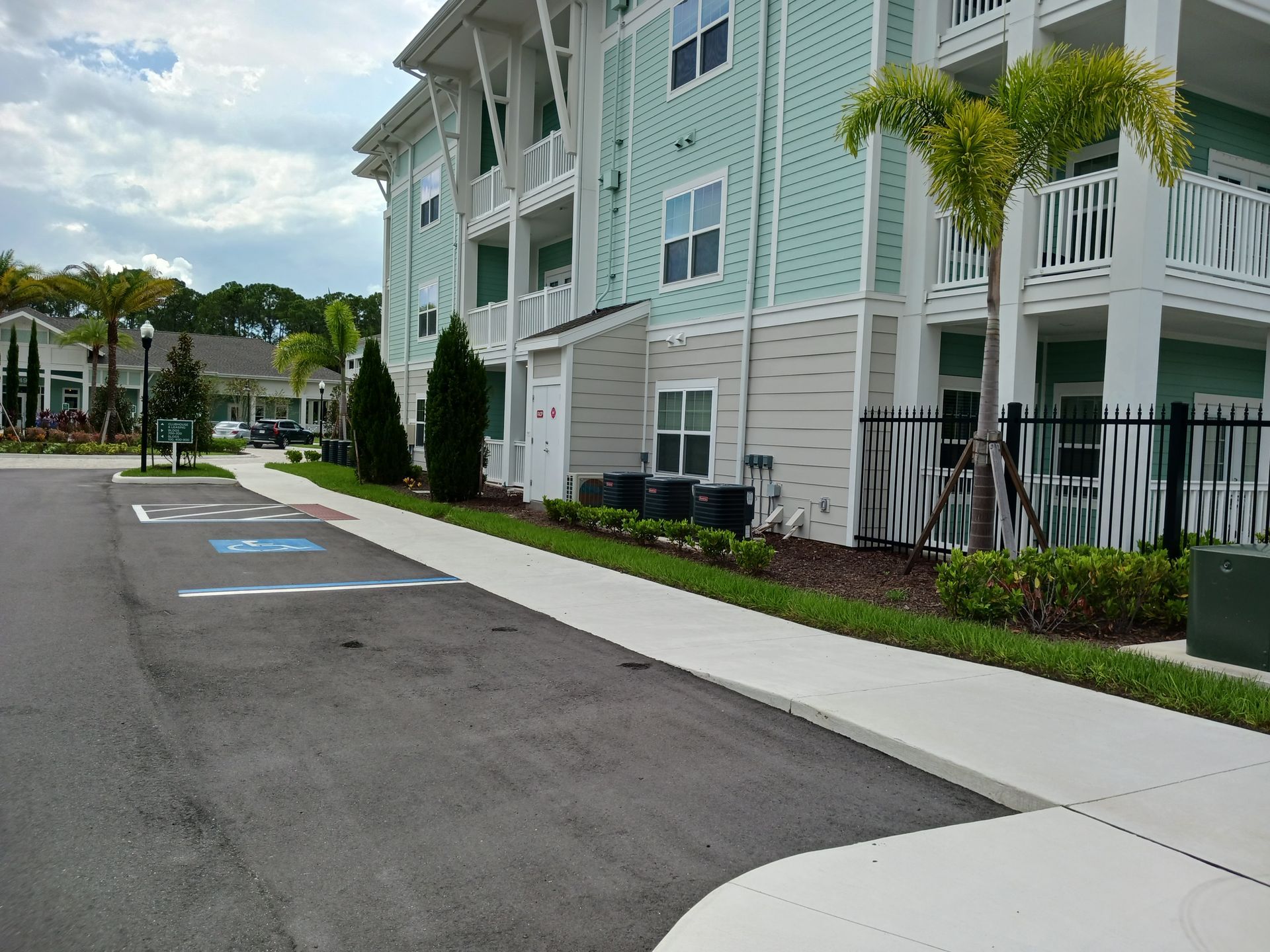 A large apartment building with a handicapped parking spot in front of it