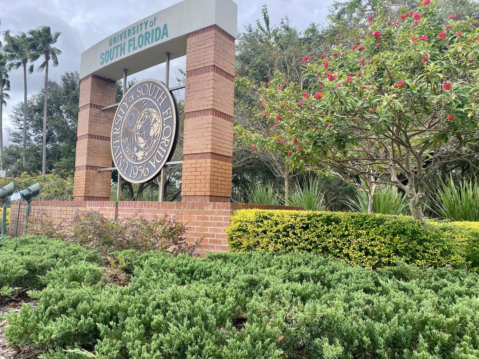 A sign for south florida is surrounded by bushes and trees.
