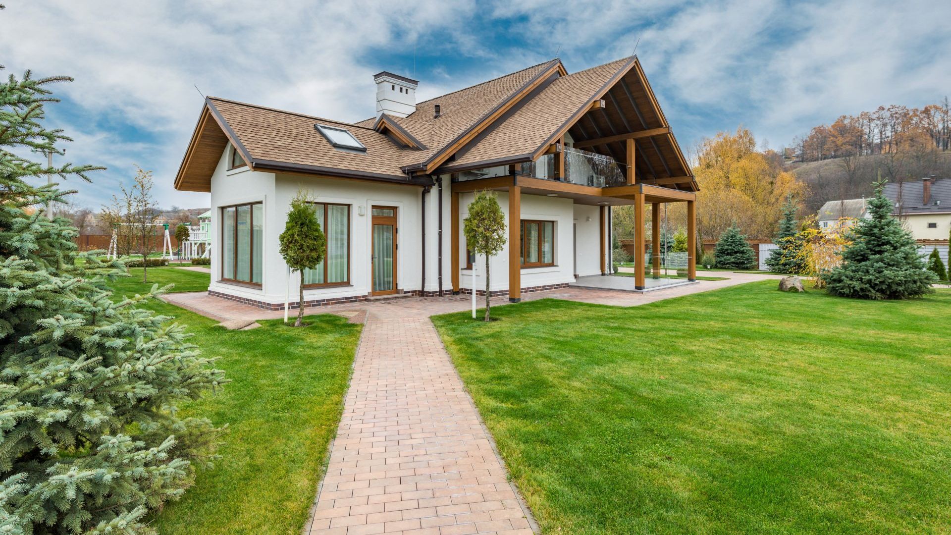 A large white house with a wooden roof and a brick walkway leading to it. -Crowders Landscaping