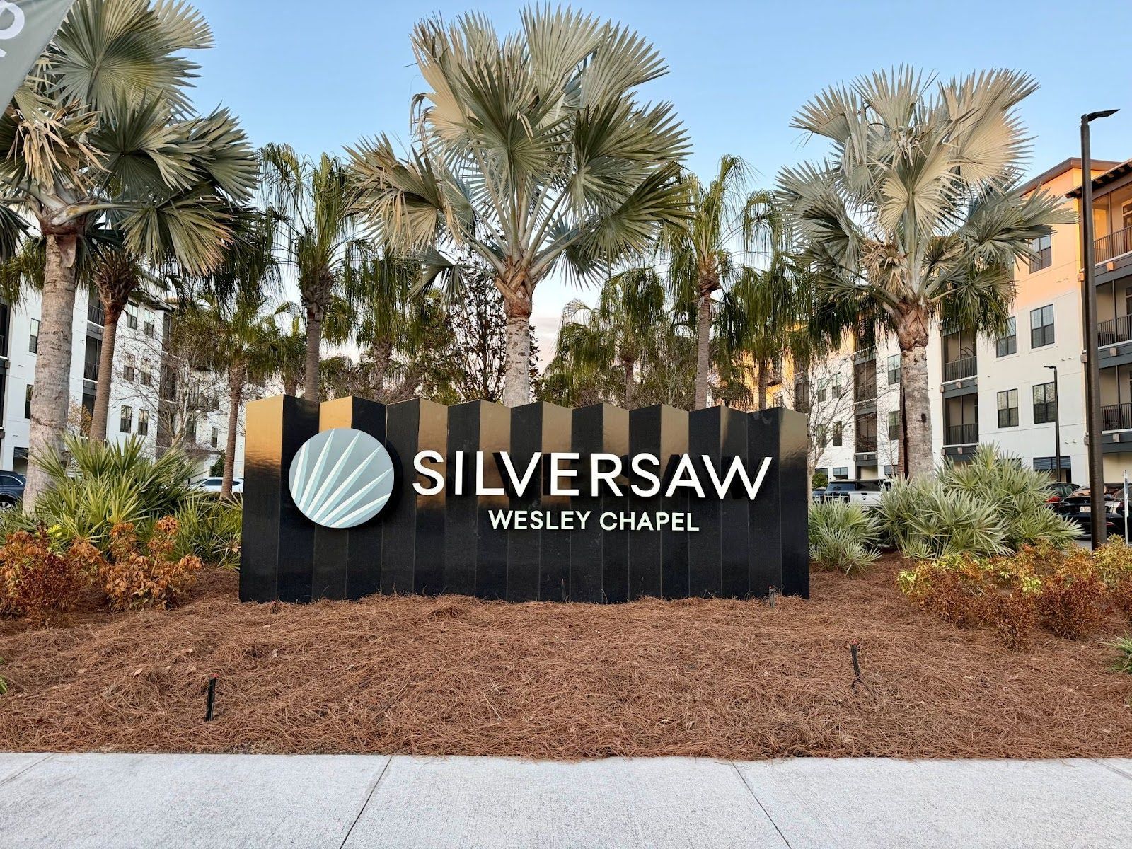 Silversaw Wesley Chapel sign in a landscaped outdoor area with palm trees and apartment buildings