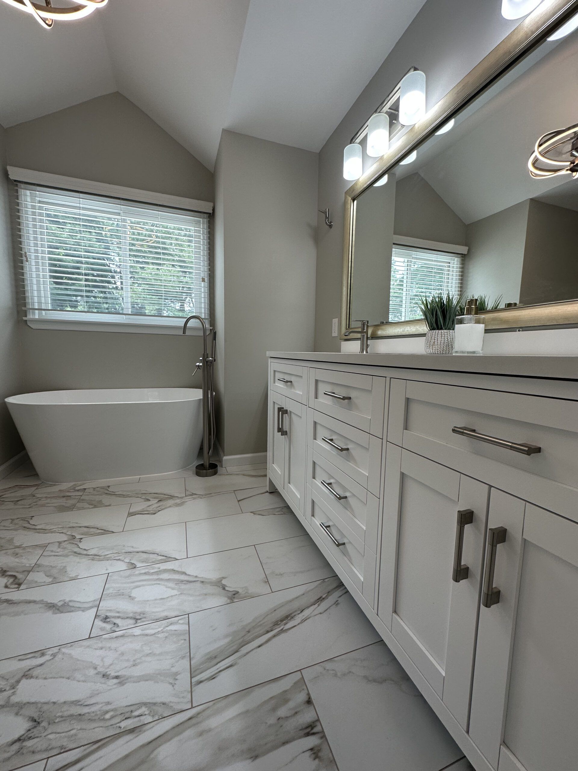 A bathroom with a tub , sink and mirror