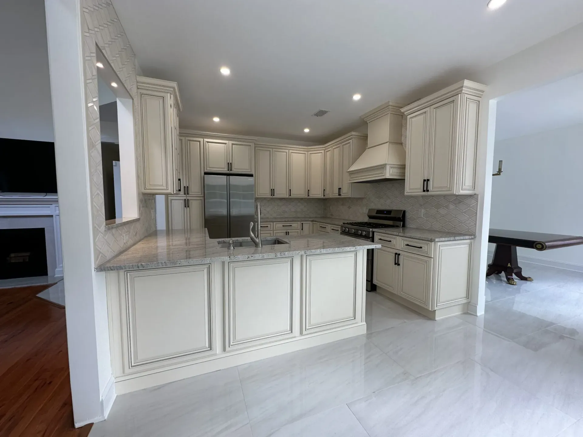Bright modern kitchen with white cabinets, stainless steel appliances, and a large island.