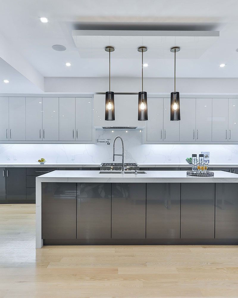 A kitchen with gray cabinets and a white counter top