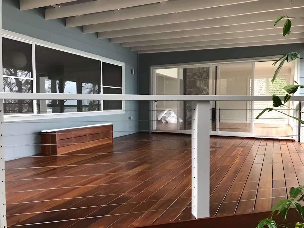 A Wooden Deck With a White Railing and Sliding Glass Doors — East Maitland Building In Branxton, NSW