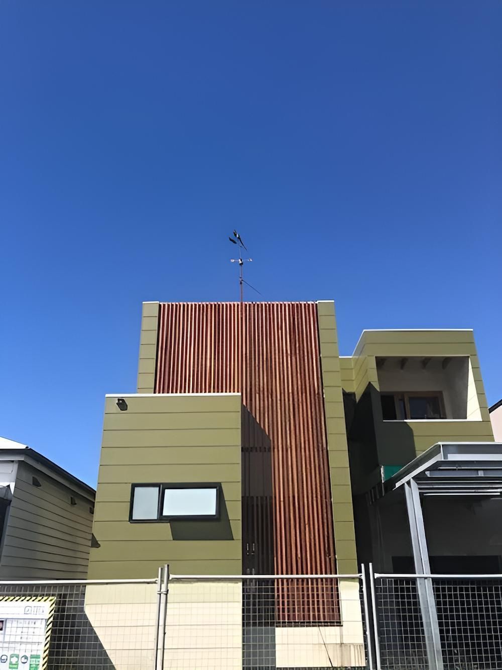 A Building With a Fence Around It and a Blue Sky in the Background — East Maitland Building In Tenambit, NSW