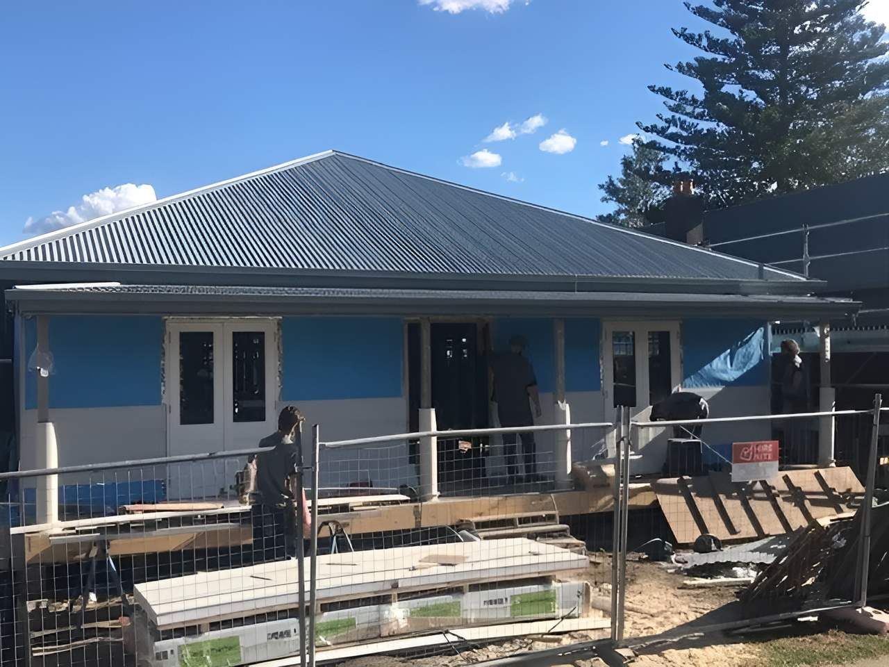 A Blue and White House is Under Construction With a Fence Around It — East Maitland Building In Newcastle, NSW