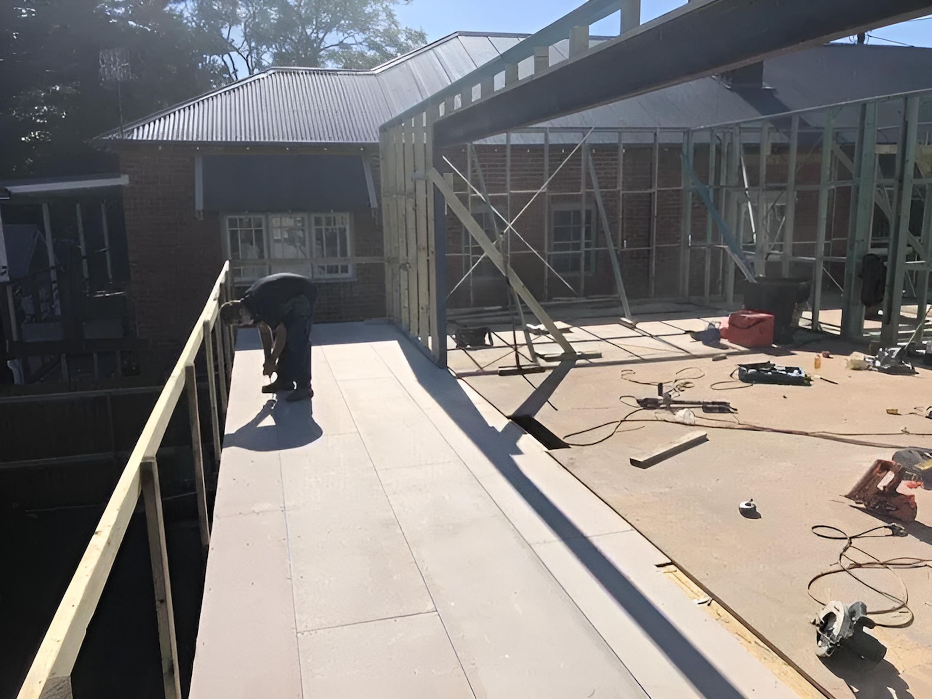 A Man is Working on the Roof of a Building Under Construction — East Maitland Building In Lake Macquarie, NSW