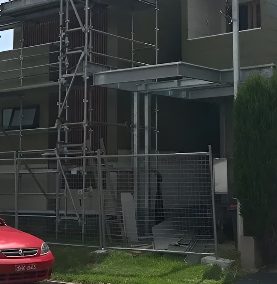 A Red Car is Parked in Front of a Building Under Construction — East Maitland Building In Newcastle, NSW