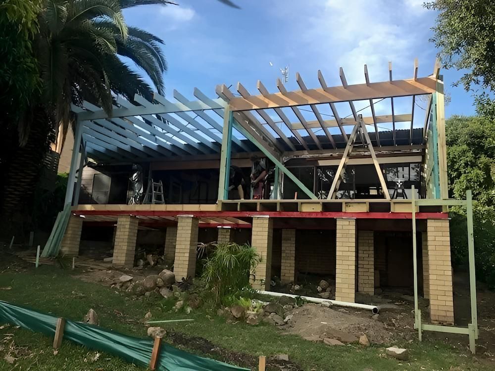 A House is Being Built on Stilts With a Wooden Roof — East Maitland Building In Lake Macquarie, NSW