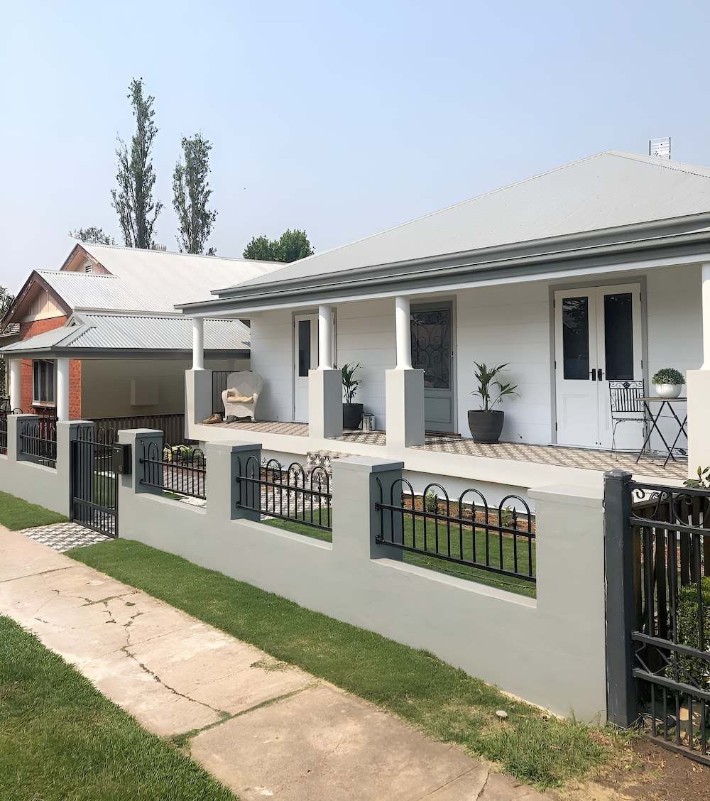 A White House With a Fence Around It and a Porch — East Maitland Building In Tenambit, NSW