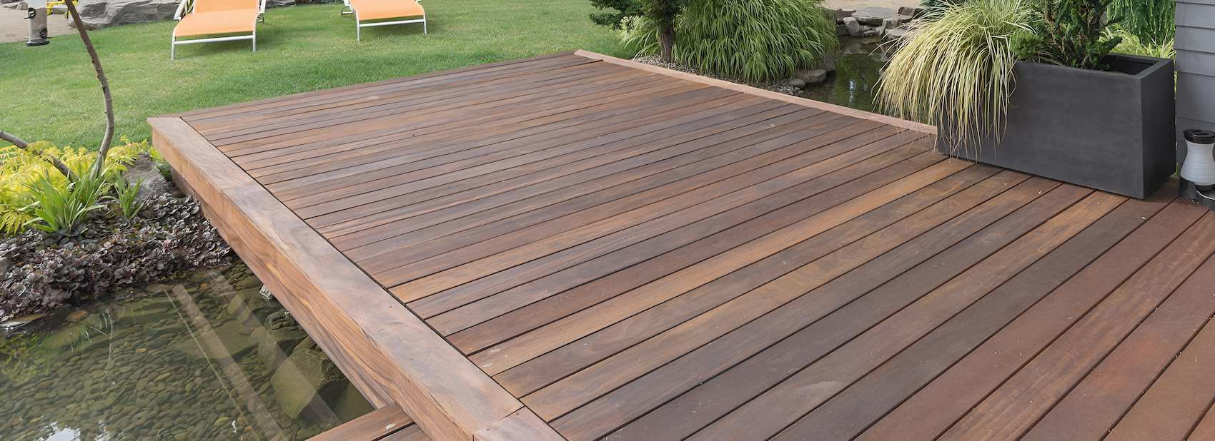 A Wooden Deck With Lawn Chairs and a Pond in the Background — East Maitland Building In Branxton, NSW