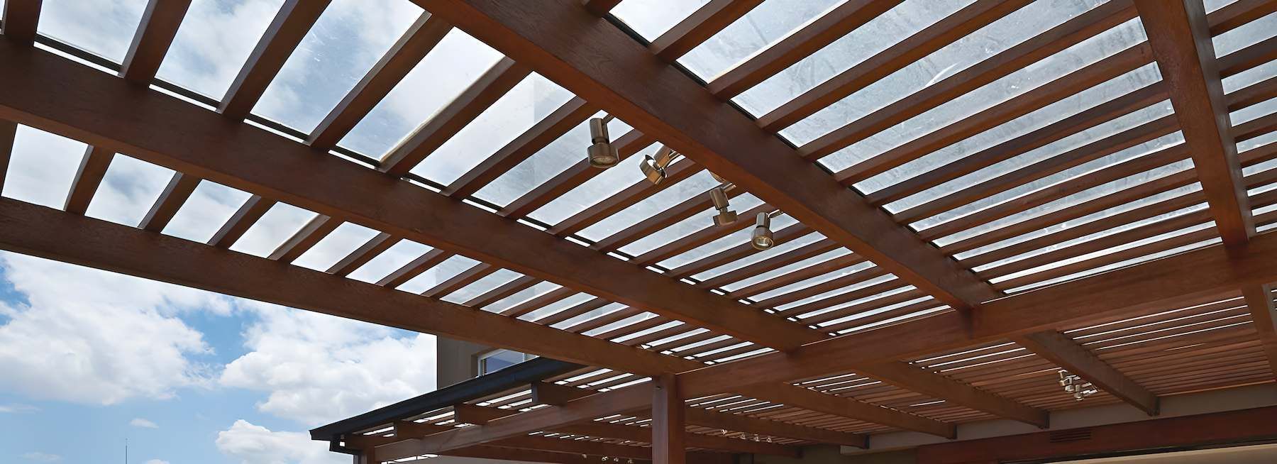 Looking Up at a Wooden Pergola With a Blue Sky in the Background — East Maitland Building In Lake Macquarie, NSW