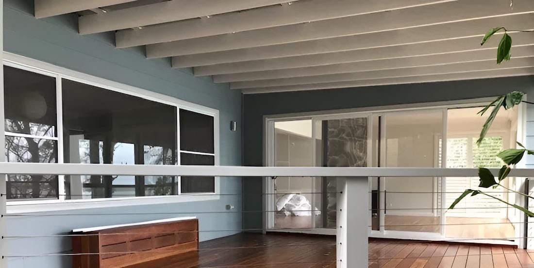 A Large Empty Room With a Wooden Floor and a White Railing — East Maitland Building In Cessnock, NSW