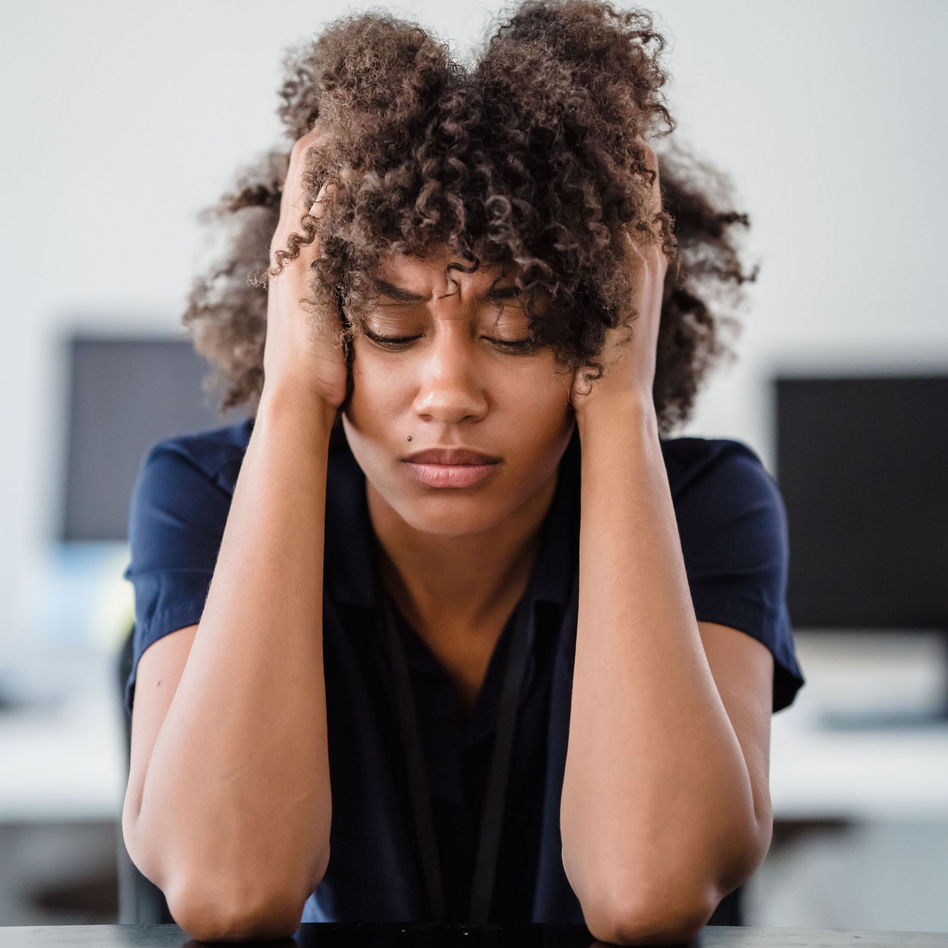 A woman appears overwhelmed with stress.