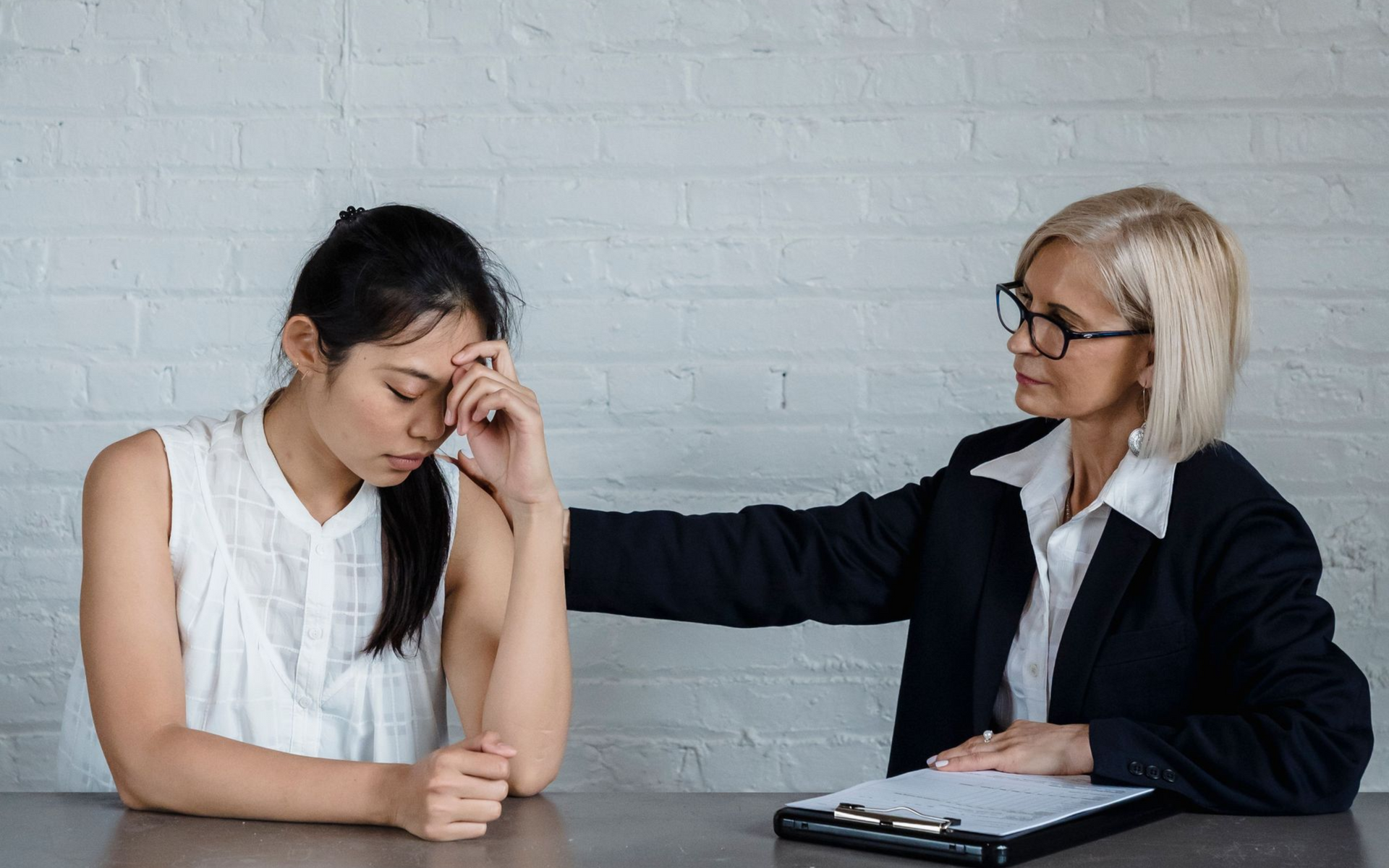 A woman who appears overwhelmed is comforted by her therapist.