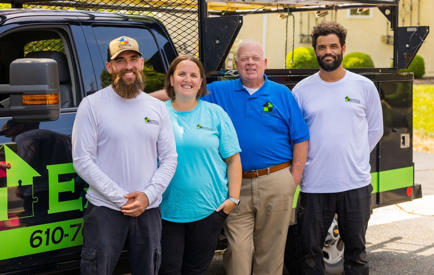 A group of people are posing for a picture in front of a truck.
