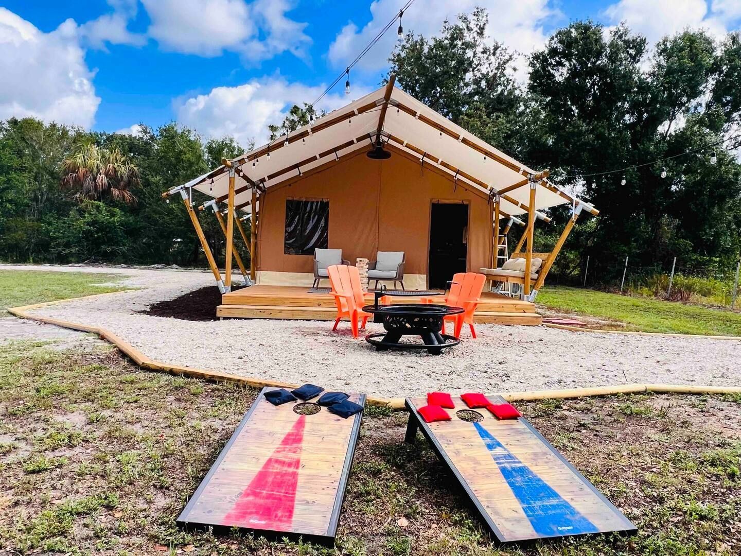 Two cornhole boards are sitting in front of a tent.