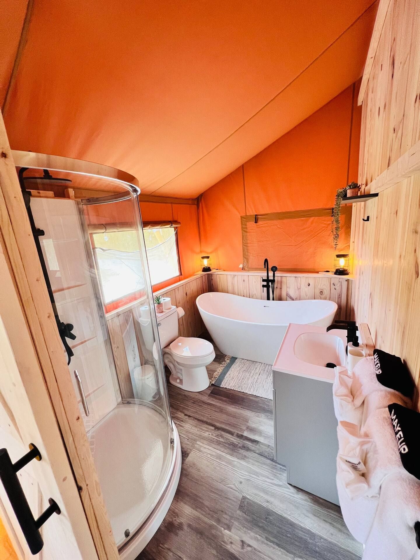A bathroom with a tub , toilet , sink and shower.