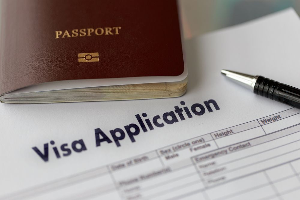 A passport is on top of a visa application