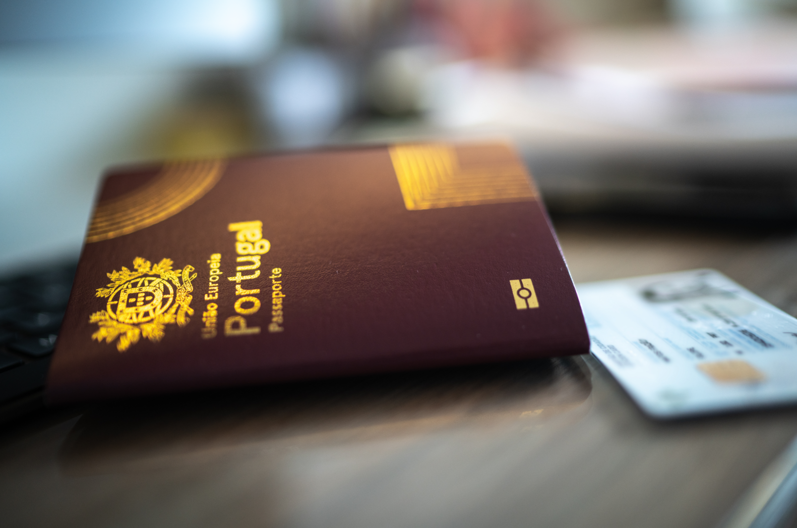 A passport lies on a table next to a credit card.