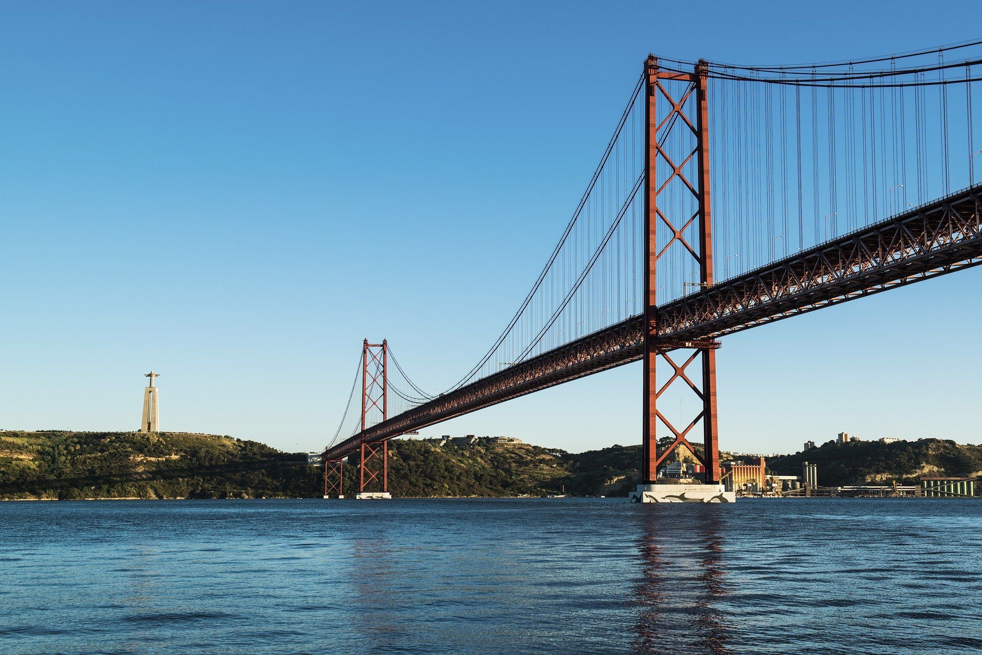 Uma ponte sobre um corpo de água com um farol ao fundo