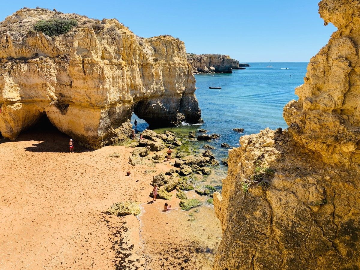 Uma praia cercada por rochas e um corpo de água