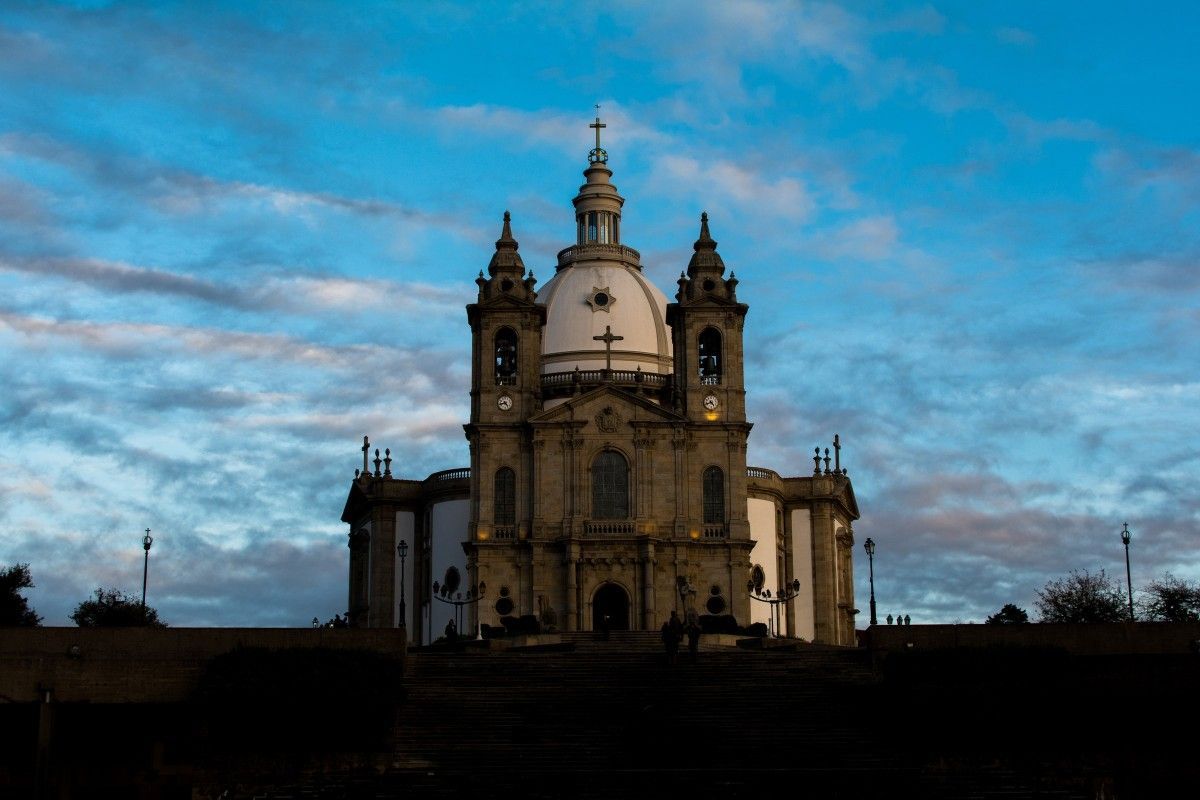Uma grande igreja com um céu azul ao fundo.