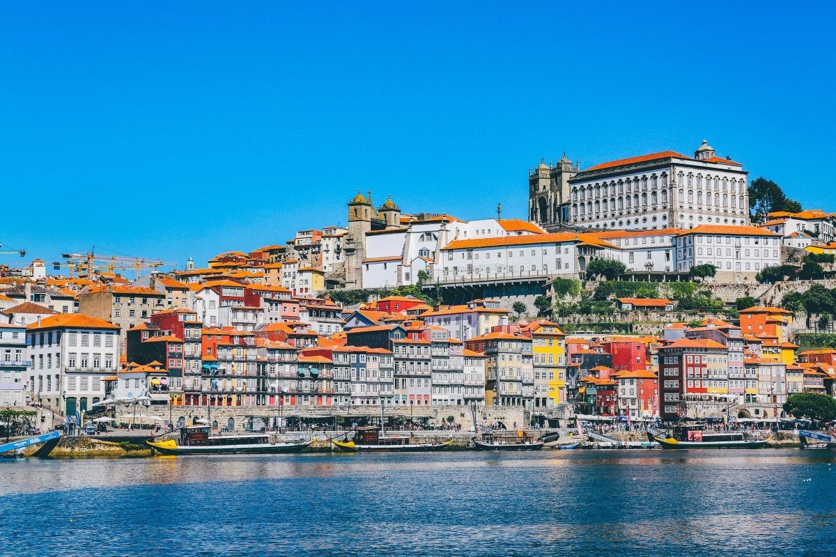 Uma cidade situada no topo de uma colina próxima a um corpo de água.