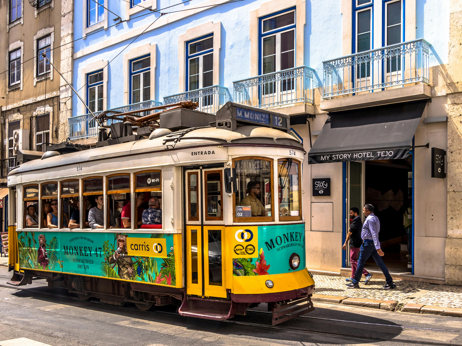 Um carrinho amarelo e azul está estacionado em frente a um prédio
