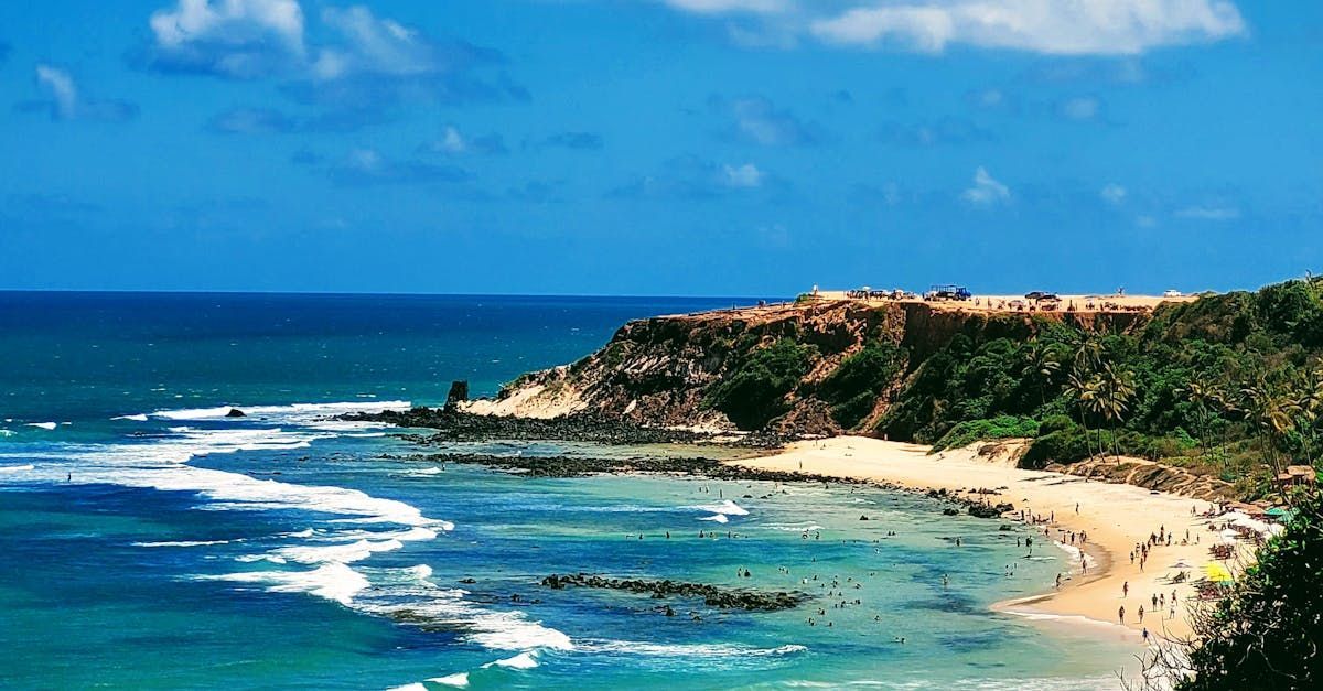 Uma praia com muita gente e um grande corpo de água