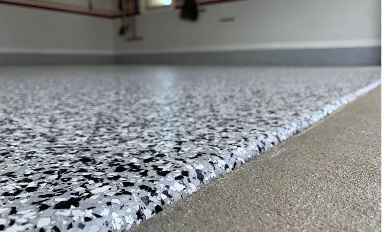 Speckled epoxy garage floor with a smooth gray edge detail