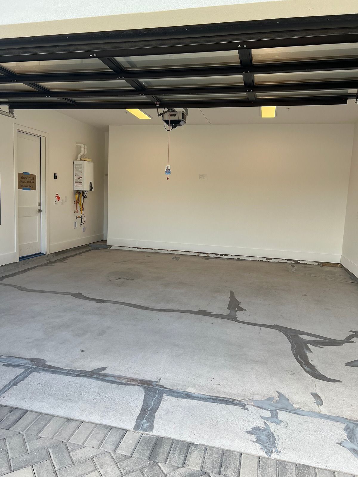 Empty residential garage with concrete floor, white walls, and an open overhead door.