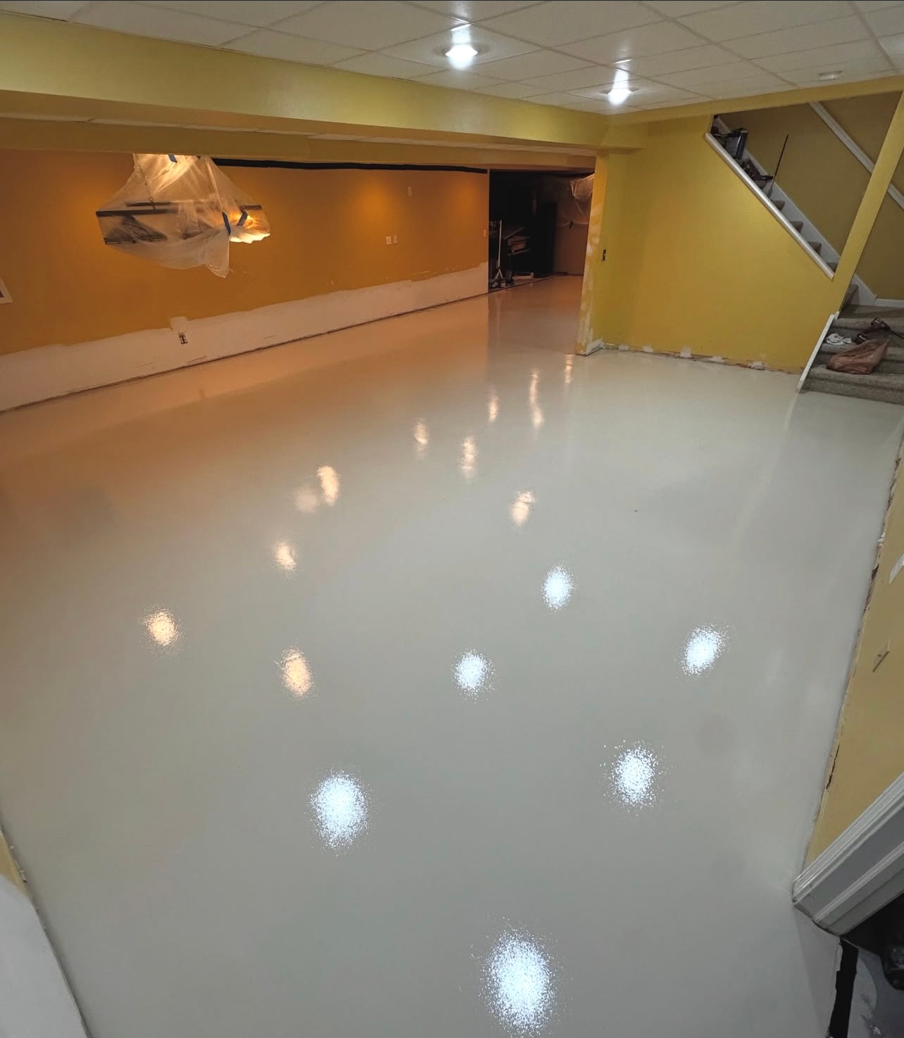 Empty glossy indoor room with yellow walls and bright reflections on a polished white floor