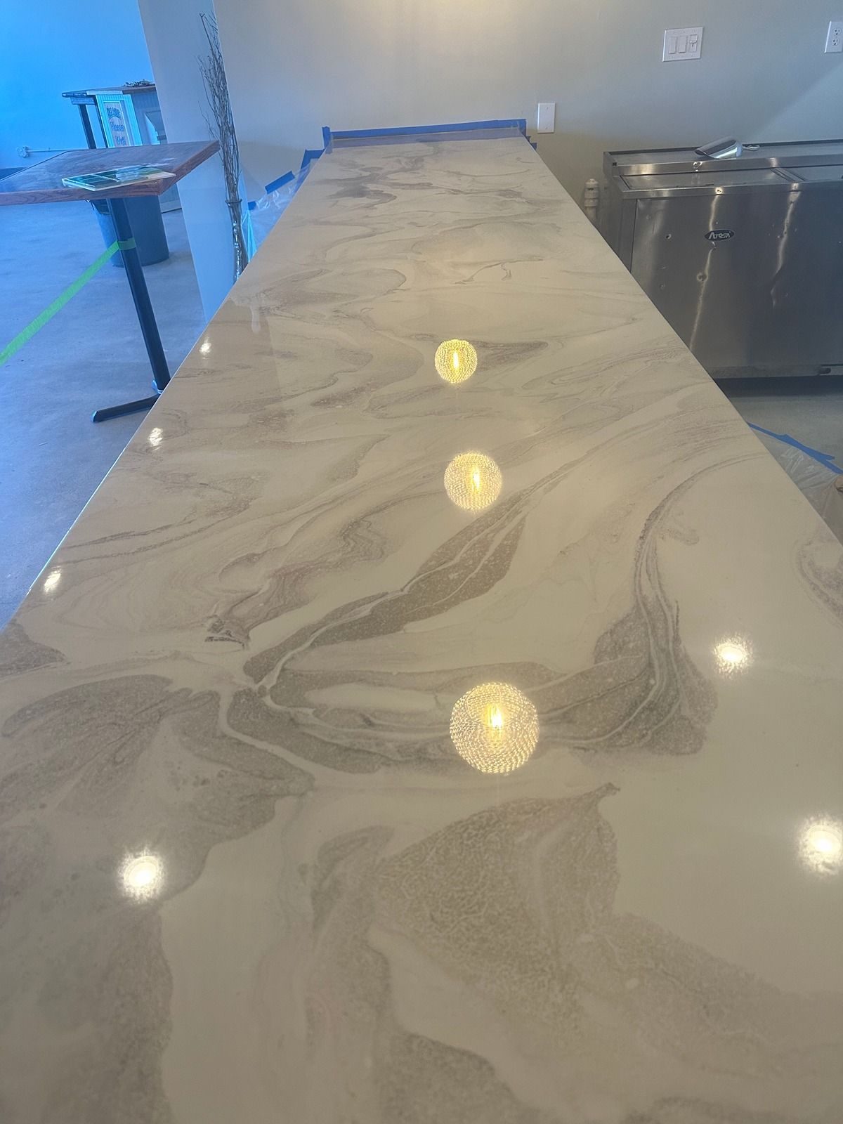Marble countertop with three round reflections in a kitchen prep area