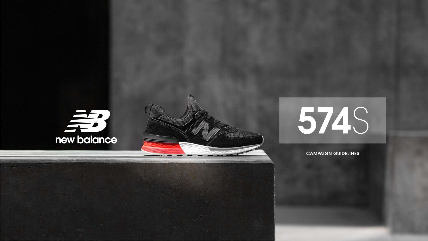 A pair of new balance 574s sneakers are sitting on top of a concrete block.